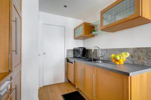 a kitchen with a sink and a bowl of fruit on the counter at Flat Alexandrie - Superbe appartement a Paris in Paris