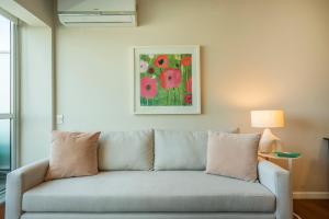 a couch in a living room with a painting on the wall at Recoleta Apartment Amazing National Library unique view powered by Argenhost -A13A- in Buenos Aires +50 photos