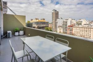 a white table and chairs on a balcony with a view at Recoleta Apartment Amazing National Library unique view powered by Argenhost -A13A- in Buenos Aires