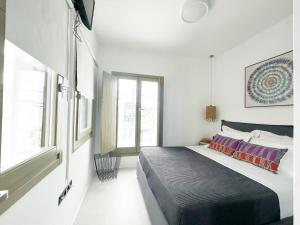 a bedroom with a large bed and a window at Joelia Suites in Naousa Paros with private jacuzzi! in Naousa