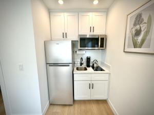 eine weiße Küche mit einem Kühlschrank und einer Spüle in der Unterkunft RP415B - Inviting 1-Bedroom Haven in Captivating Burbank in Burbank