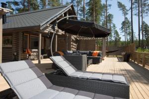 a patio with furniture and an umbrella on a deck at Yyteri Beach Lomakeskus, Havulinna 27 in Pori