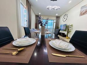 a dining room table with plates and napkins on it at Aspire Tower - Breezy Two Bedroom in Juffair in Manama