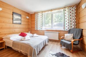 een slaapkamer met een bed, een stoel en een raam bij Willa Marta Zakopane in Zakopane