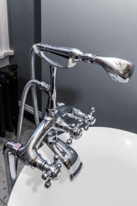 a bathroom sink with a faucet on top of it at Luxury Brownstone - Walk to ALL - Washington Park in Cincinnati