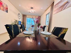 a dining room with a wooden table and chairs at Aspire Tower -Chic City Escape Juffair in Manama
