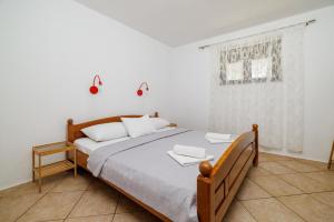 a bedroom with a bed with white sheets and a window at Apartment Klara in Senj