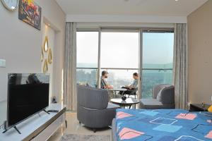 um quarto de hotel com uma cama e uma TV em High Rise Den 1 em Gurgaon