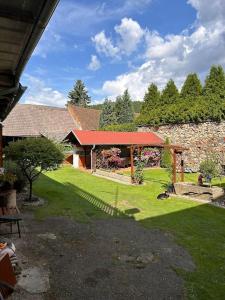 a house with a yard with a stone wall at Apartmán u Poustevníka in Kájov