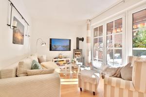 a living room with white furniture and a tv at Ferienhaus Ostseeferien bei Bella Appartement 1 in Schürsdorf