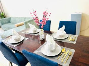 a dining room table with plates and napkins on it at Aspire Tower # Serenity Suite Juffair in Manama