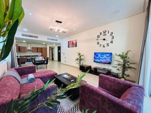 a living room with two purple couches and a tv at Aspire Tower -Chic City Escape Juffair in Manama