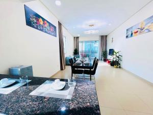 a living room with a table and a dining room at Aspire Tower-The Tranquil Haven in Manama