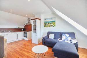 un salon avec un canapé bleu et une table dans l'établissement "Klein-Wiebke" in der Villa Wilhelmine, à Borkum 27 autres photos