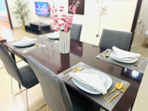 a dining room table with chairs and a vase of flowers at Aspire Tower # Peaceful Pad Juffair in Manama