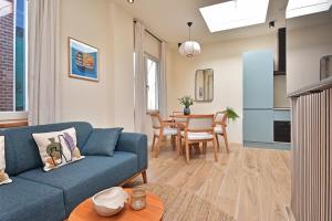 a living room with a blue couch and a table at Curated apartment near Scheveningen beach in Scheveningen