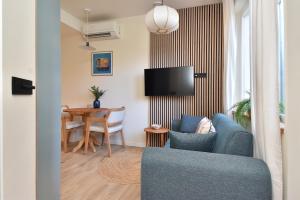 a living room with a blue couch and a table at Curated apartment near Scheveningen beach in Scheveningen