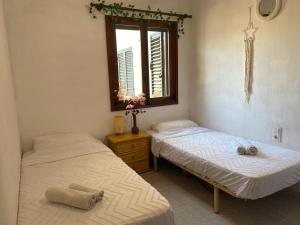 two twin beds in a room with a window at Beach Appartement Denia in Denia