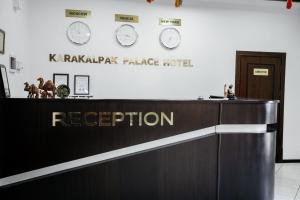 un mostrador de recepción del hotel con relojes en la pared en Karakalpak Palace Hotel, en Nukus