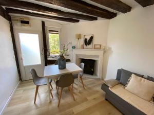 a living room with a table and a couch at Maison de ville avec jardin à 5 minutes de Lisieux in Beuvillers
