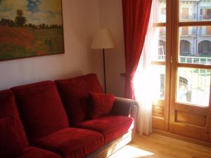 una sala de estar con un sofá rojo junto a una puerta en Apartamento Lamatriz Dequin Edificio Sayo 8, en Benasque