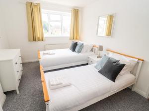 a bedroom with two beds and a couch at 17 Sands Close in Broadway