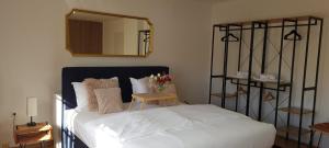 a bedroom with a white bed and a mirror at aNNa s Cozy Home with Private Forest, Canopy Terrace & Parking, near Red Bull Ring in Sankt Michael in Obersteiermark