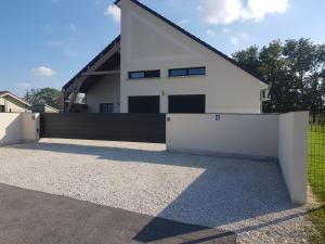 a white house with a black and white garage at Au Cœur de la Vannerie in Fayl-Billot