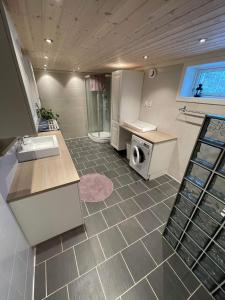 a kitchen with a sink and a washing machine in it at Skoglund privat Villa in Trysil