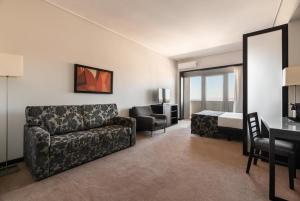 a living room with a couch and a bedroom at Exe Praia Golfe in Espinho