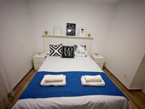 a bedroom with a large bed with two towels on it at La Vida es Bella Córdoba in Córdoba