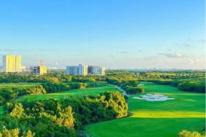 an aerial view of a golf course with buildings in the background at Apartamentos Modernos en Quintana Roo Cancun México in Cancún