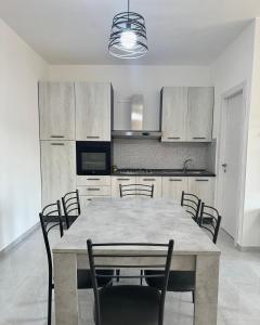 a dining room with a table and chairs in a kitchen at Residence ESTIVO in Cirò Marina