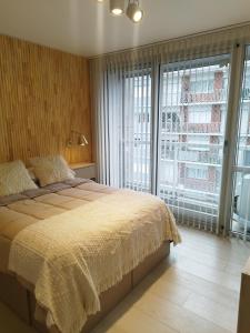 Un dormitorio con una cama y una ventana grande. en Altamar, en Mar del Plata