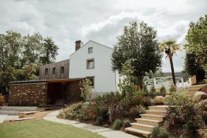 una casa blanca con un jardín delante en Casa de Covés, en Puentedeume