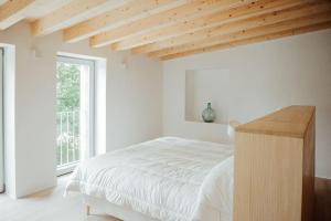 Un dormitorio blanco con una cama y una ventana. en Casa de Covés, en Puentedeume 43 fotos más