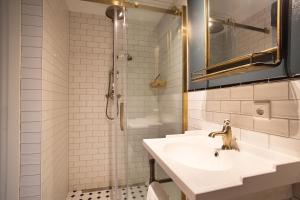 スケベニンゲンにあるContemporary apartment near the beachの洗面台とシャワー付きの白いバスルーム +26枚の写真