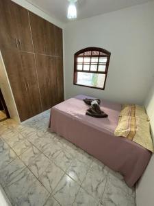 a bedroom with a bed and a window in a room at Recanto dos Cajueiros in Cabo Frio
