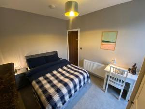 a bedroom with a bed and a table with a chair at Fern House in Cork
