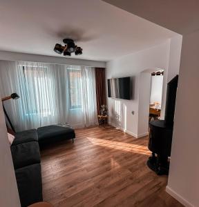 a living room with a couch and a tv at Divine moments apartment@Calbucet ski slope in Predeal