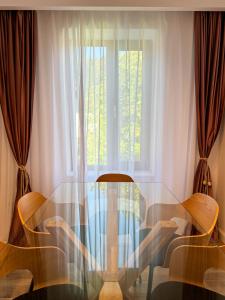 a glass table with two chairs and a window at Divine moments apartment@Calbucet ski slope in Predeal +20 photos
