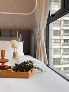 a bed with a wooden tray with a plant on it at Muji Full Seaview Royal Strand with 2CarParks FOC Netflix Access and Youtube Premium 3Beds 3Bath for 6-12pax by Minshuku in Johor Bahru