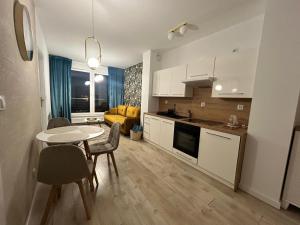 a kitchen and living room with a table and chairs at Apartament Skarbowa Star in Leszno