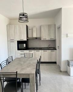 a kitchen with a dining room table and chairs at Residence ESTIVO in Cirò Marina +18 photos