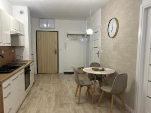 a kitchen and dining room with a table and chairs at Apartament Skarbowa Star in Leszno