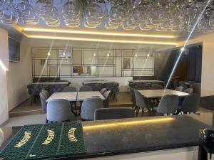 ein Esszimmer mit Tischen, Stühlen und Lampen in der Unterkunft Hotel FOCUS in Prilep