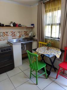 a kitchen with a table and chairs and a table and a stove at kitinetes Atômico in Torres