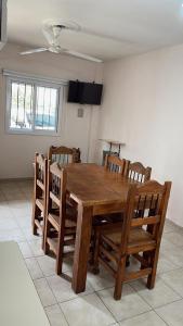 een houten eettafel en stoelen in een kamer bij Apart Hotel Pueblo Viejo in San Juan