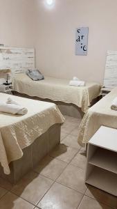 een kamer met twee bedden en een tafel erin bij Apart Hotel Pueblo Viejo in San Juan