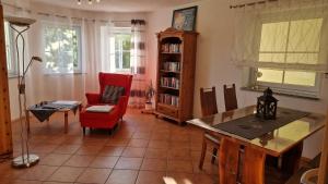 a living room with a table and a red chair at "Villa Sabine" in Waidhaus